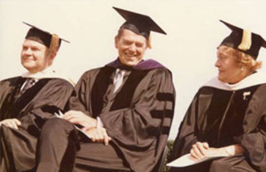 Norvel Young sitting beside President Ronald Regan and Blanche Seaver in graduation regalia