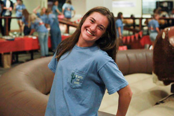 Lanie Jones photographed in her blue sorority shirt, pictured smiling in front of a mechanical bull