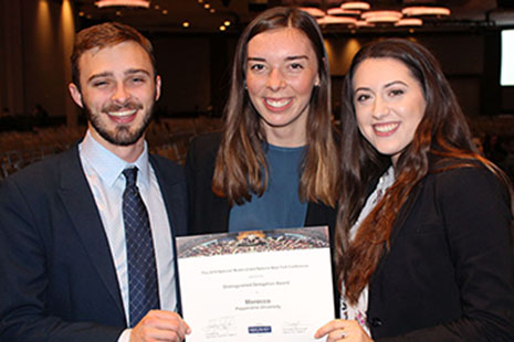 Three students holding Distinguished Delegation award.