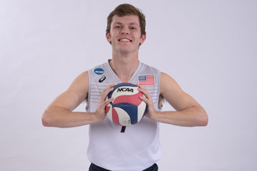 Spencer Wickens posing for his volleyball team photo, grasping a volleyball in between both hands
