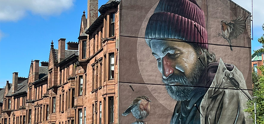 Mural on a building of a man holding a bird