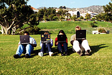 Image: Students sitting on lawn using laptops