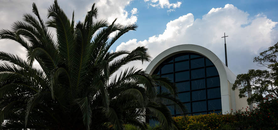 Exterior photo of Stauffer Chapel pictured with a palm tree in front