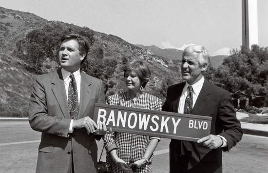 Black and white photo of President Davenport and Mr. and Mrs. Banowsky holding Banowsky Blvd street sign