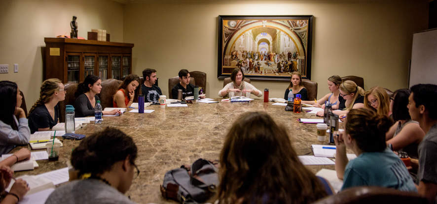 Students seated around a round table in the Great Books Room in Payson Library