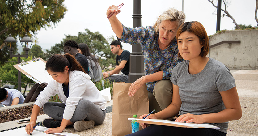 Professor teaching a student outside pointing to the distance