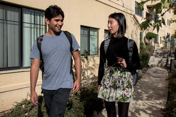 Students walking alongside a dorm on campus