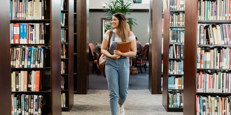 Seaver student walking in Payson Library