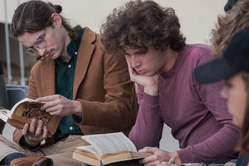 Male students reading a book
