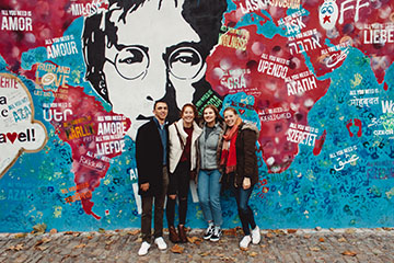 people standing by wall art of John Lennon