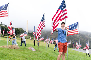 people at inserting flags in the ground at the Malibu campus