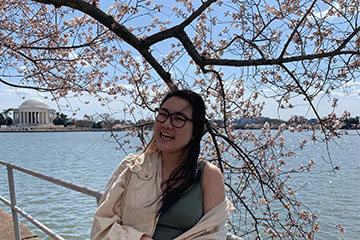 Student posing in front of the cherry blossoms in DC