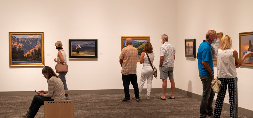 visitors looking at numerous pieces of art