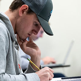 Student in a cap taking notes