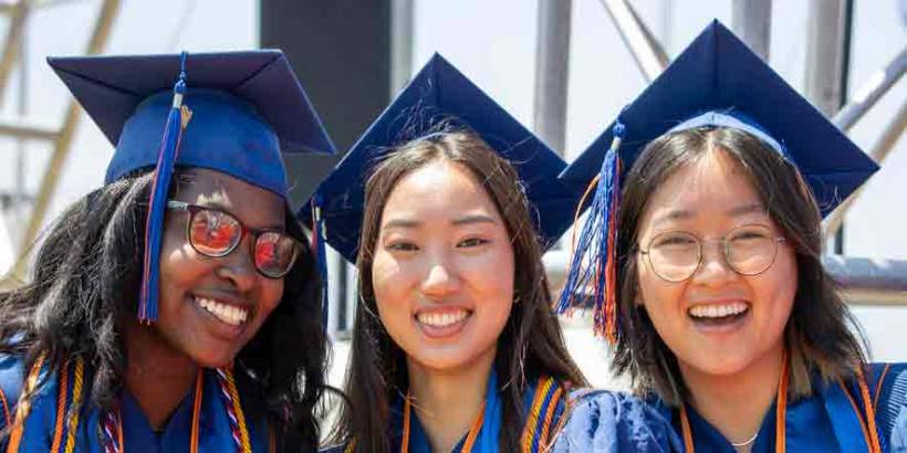 Female accounting bachelors degree students in graduation caps and gowns