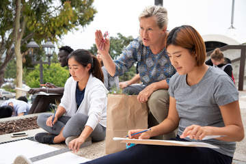 Seaver art profressor instructing two female students outside