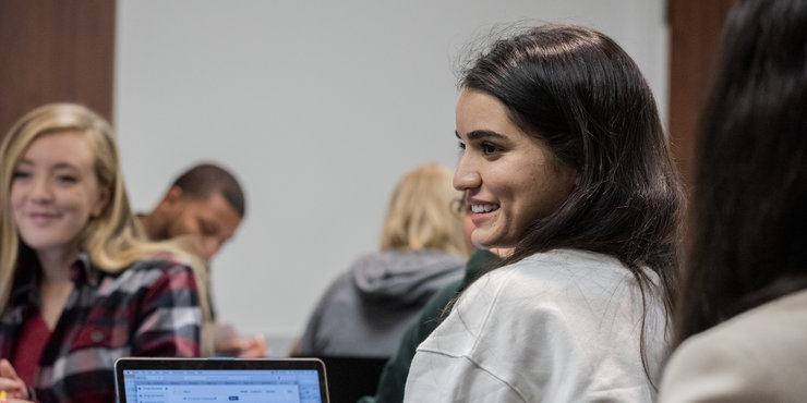 Seaver student in class looking past her opened laptop