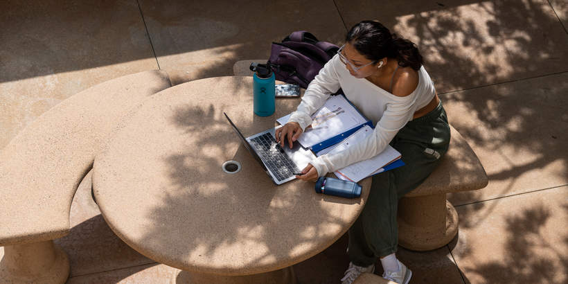Student working on a laptop in Mullins Town Square