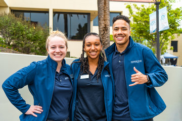 Three students wearing a blue Pepperdine jacket