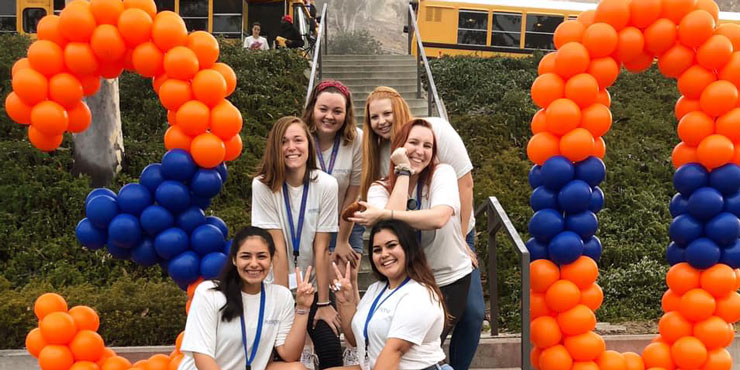 Isabel Cornavaca posing with friends in front of a balloon display