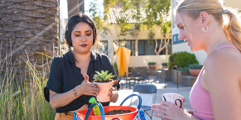 Student planting a flower in a pot