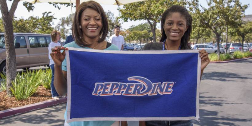 Seaver student and mom holding a Pepperdine flag