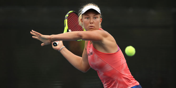 Ashley Lahey, intently focused on the tennis ball in front of her, arm outstreched, in position to return the pass