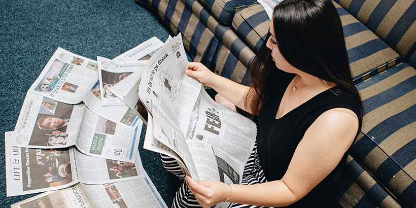 Maria Valente sitting down reading newspapers