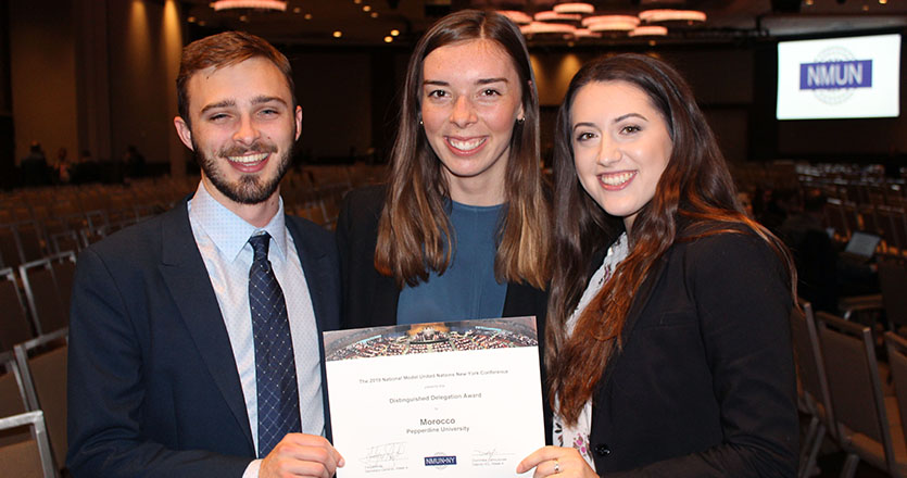 Students, Steve Kerr, Morgan Bedford, and Amy Roth holding Distinguished Delegation Award 