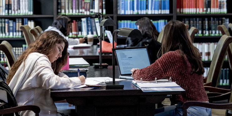 Seaver students studying in Payson library surrounded by laptops and notebooks 