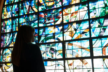 Student looking outside stained glass in chapel