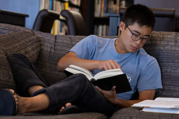 Student reading on a couch in Payson