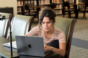 Student typing on her laptop in Payson library