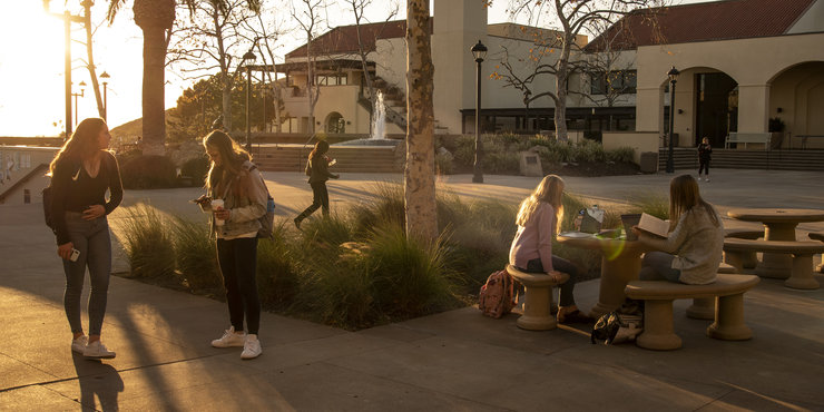 Students walking around Mullins Town Square as the sun sets