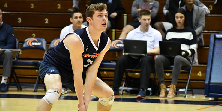 Spencer Wickens on the volleyball court, in a crouched position ready to volley the ball