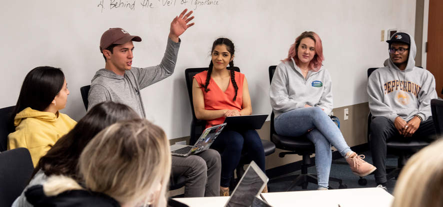 Students sitting in a semi-circle during a Communication course