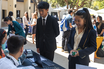 students talking at a career expo table