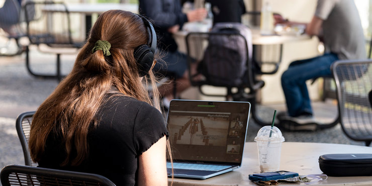 student wearing headphones, looking at laptop