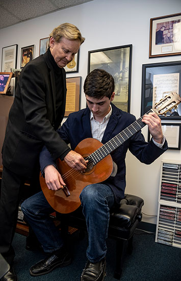 Chris Parkening adjusting his student's guitar strings