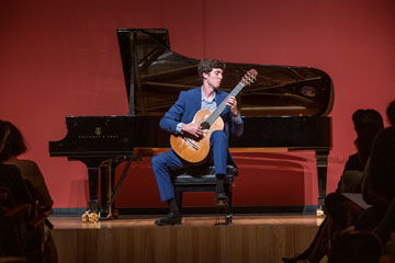 Student playing a guitar in Raitt Recital Hall