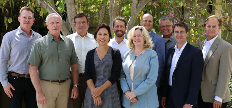 Several Music professors stand in front of a tree