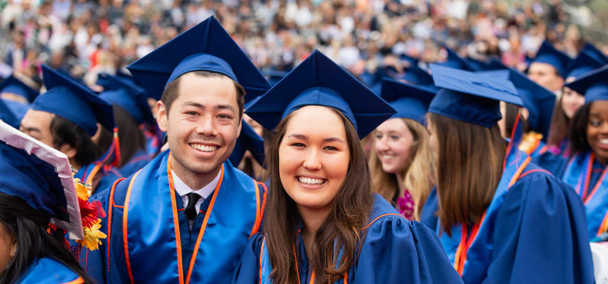 Two Seaver graduates smile for the camera in the middle of graduation