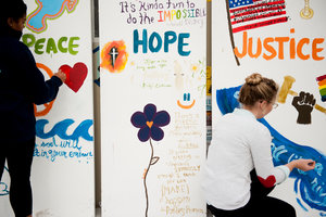 students painting wall for peace, hope, and justice