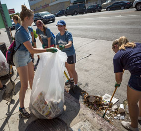 Students picking up trash off the street for Step Forward Day