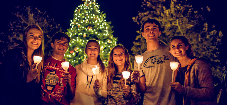 students holding Christmas lights