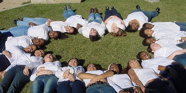 Students dressed in white lying on the grass in Alumni Park