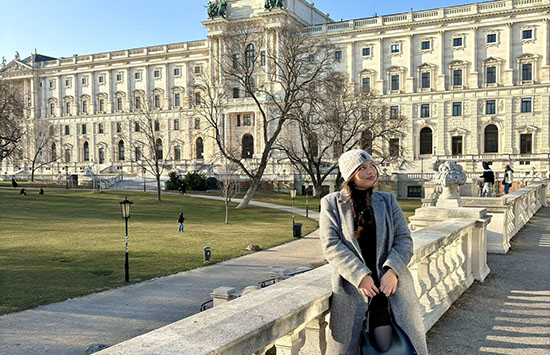 Student sitting outside at Hofburg Palace in Vienna.