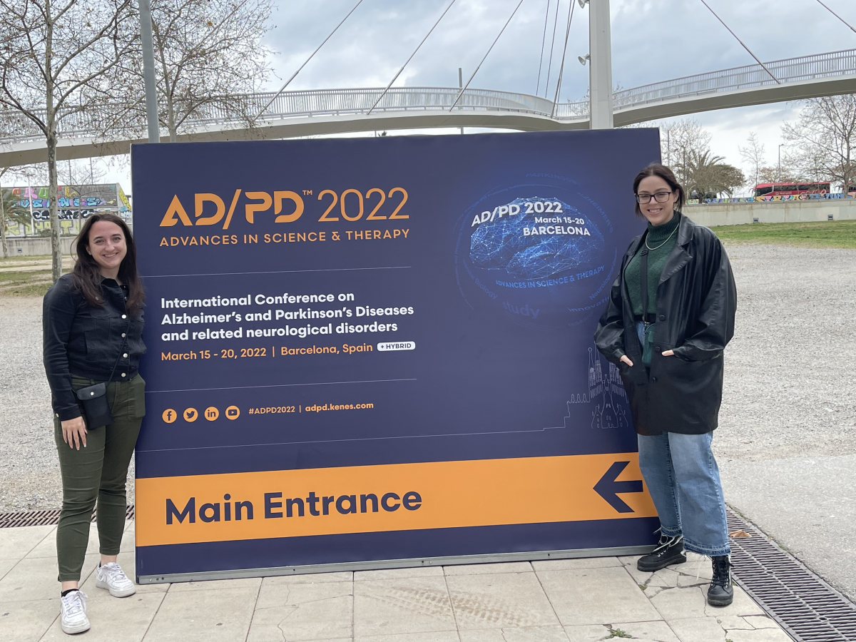 Students stand in front of conference entrance sign