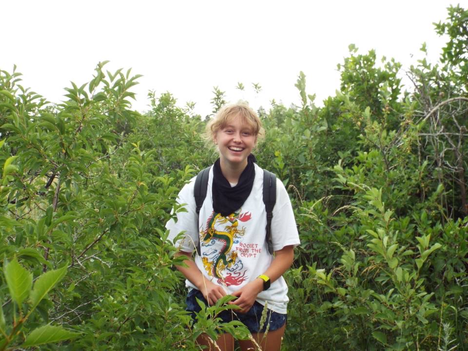 Mallory Finley surrounded by tall green plants