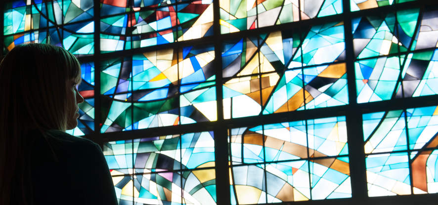 Female Seaver student looking at the stained glass windows in Stauffer Chapel